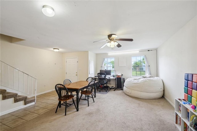 tiled dining area with baseboards, ceiling fan, stairs, and carpet