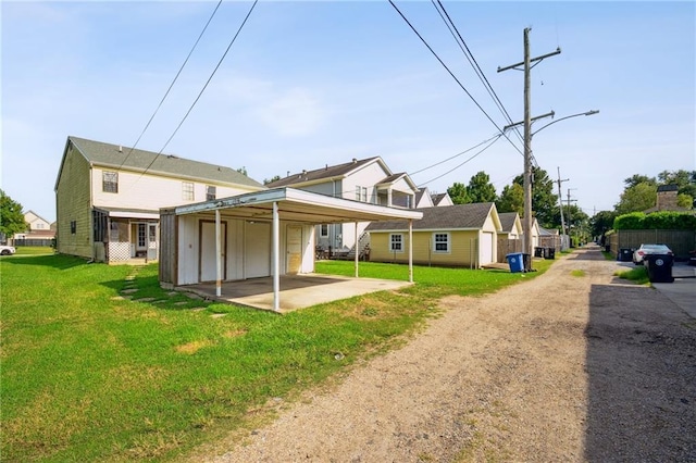 back of property featuring a lawn, driveway, and a garage