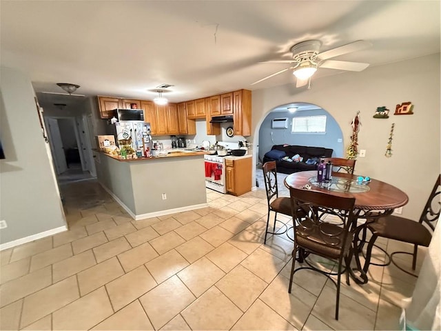 4928 Sandalwood St, New Orleans, LA 70127 - kitchen featuring ceiling fan, white gas range, a peninsula, freestanding refrigerator, and arched walkways
