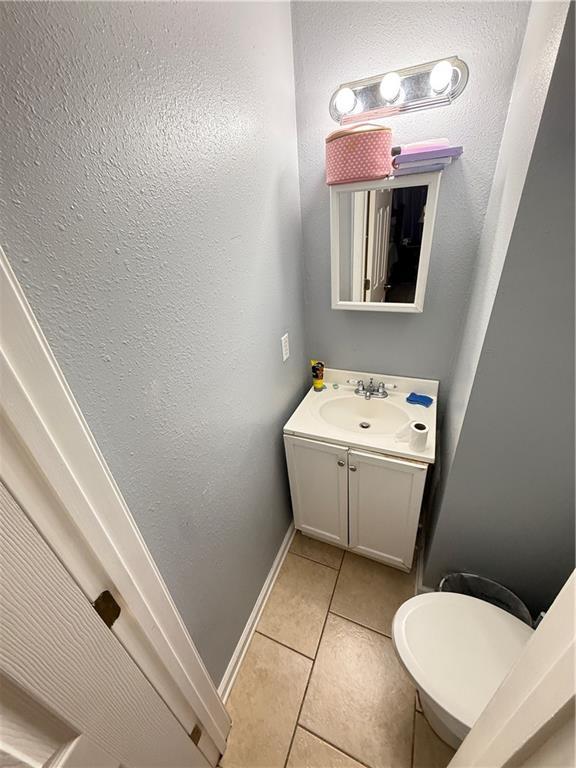 4928 Sandalwood St, New Orleans, LA 70127 - half bath with tile patterned floors, toilet, vanity, and baseboards