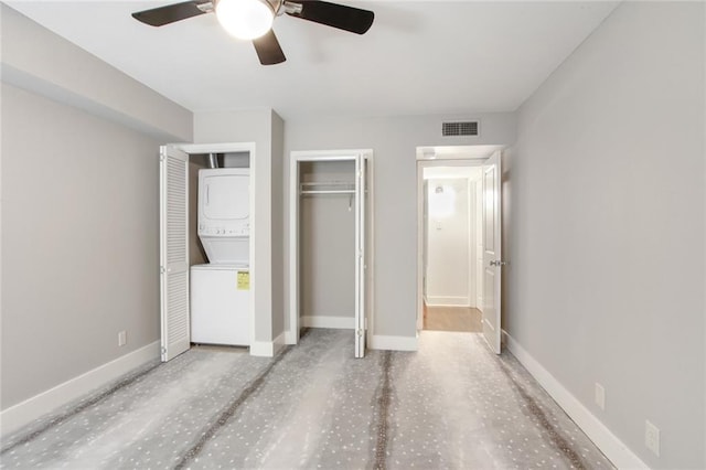 1430 Jackson Ave Unit 302, New Orleans, LA 70130 - unfurnished bedroom with stacked washing machine and dryer, a ceiling fan, and multiple closets