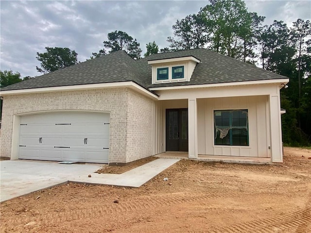 1169 Fox Sparrow Loop, Madisonville, LA 70447 - view of front of house featuring brick siding, a shingled roof, concrete driveway, and an attached garage
