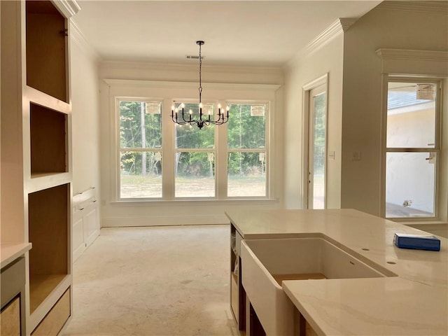 1169 Fox Sparrow Loop, Madisonville, LA 70447 - kitchen with a chandelier, hanging light fixtures, crown molding, light stone counters, and a sink