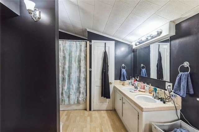119 Vine St, New Iberia, LA 70560 - bathroom featuring wood finished floors, double vanity, lofted ceiling, and ornamental molding