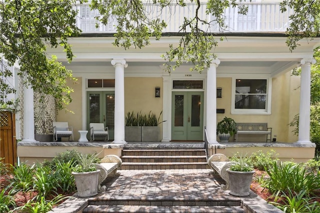 1930 Napoleon Ave, New Orleans, LA 70115 - view of exterior entry with french doors, a porch, and stucco siding