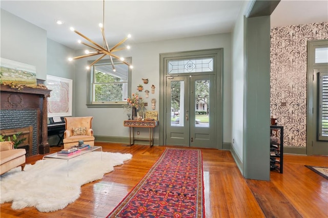 1930 Napoleon Ave, New Orleans, LA 70115 - entrance foyer featuring wood finished floors, a chandelier, a fireplace, and wallpapered walls