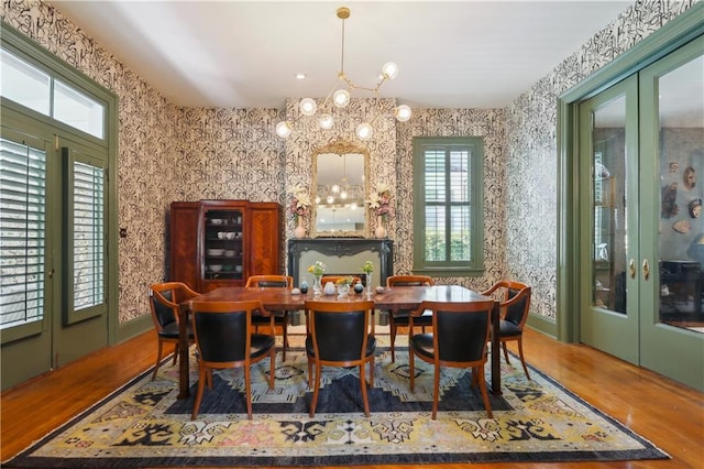 1930 Napoleon Ave, New Orleans, LA 70115 - dining area with french doors, a chandelier, wood finished floors, plenty of natural light, and wallpapered walls