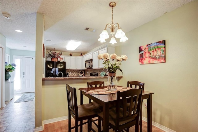 1700 Marseille Dr Unit 2, La Place, LA 70068 - dining room with a textured ceiling, baseboards, visible vents, and a chandelier