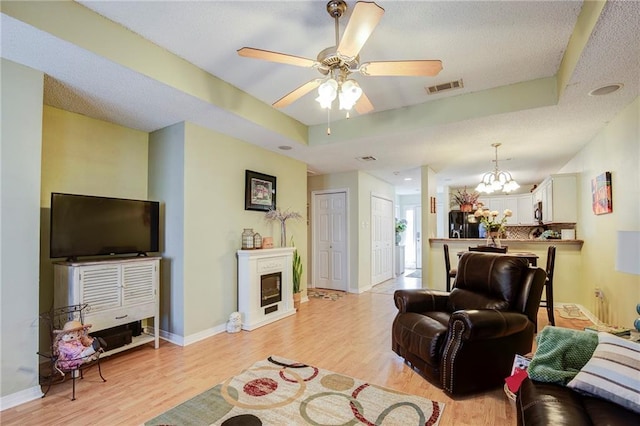1700 Marseille Dr Unit 2, La Place, LA 70068 - living area featuring a raised ceiling, a fireplace, visible vents, and light wood-type flooring