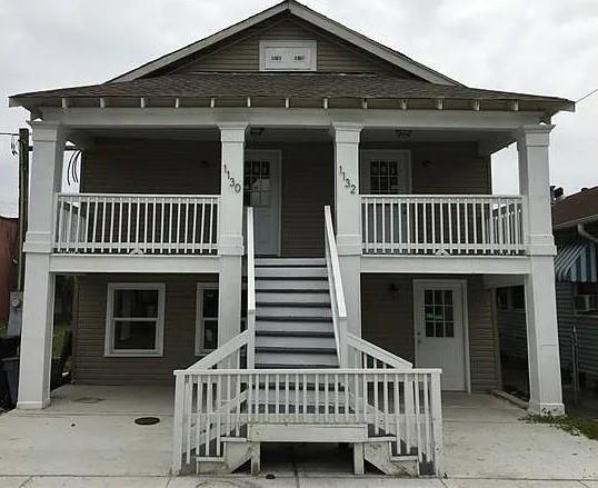 view of front of property featuring stairway and a porch