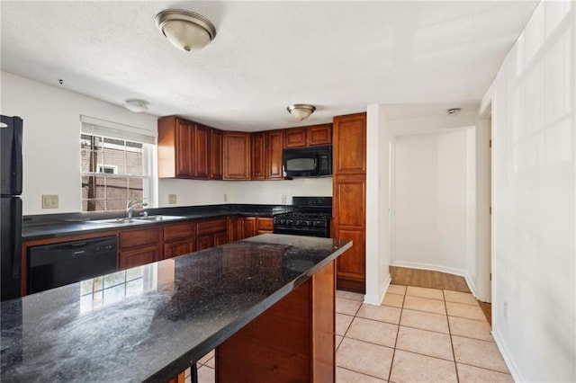 84143 Washington Ave, New Orleans, LA 70130 - kitchen featuring black appliances, dark stone counters, light tile patterned flooring, a textured ceiling, and a sink