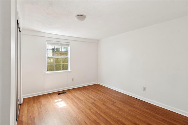 84143 Washington Ave, New Orleans, LA 70130 - empty room featuring light wood-type flooring, visible vents, and baseboards