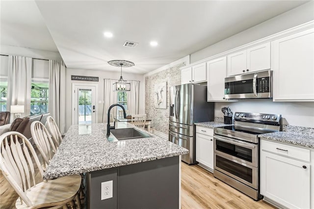 41379 Schafer Dr, Hammond, LA 70403 - kitchen featuring stainless steel appliances, white cabinetry, an island with sink, and recessed lighting