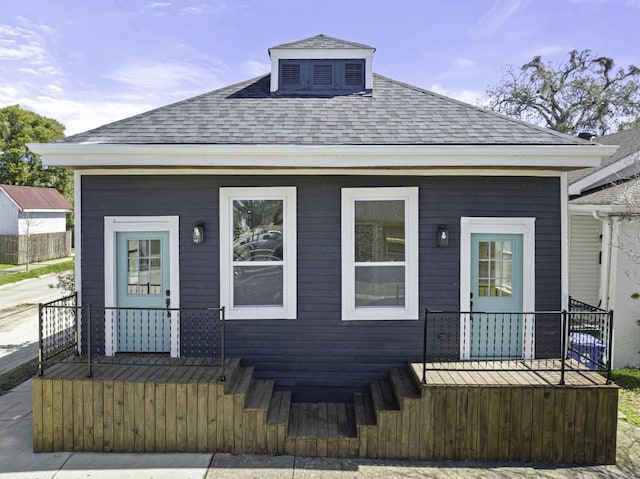 view of front facade featuring covered porch and a shingled roof