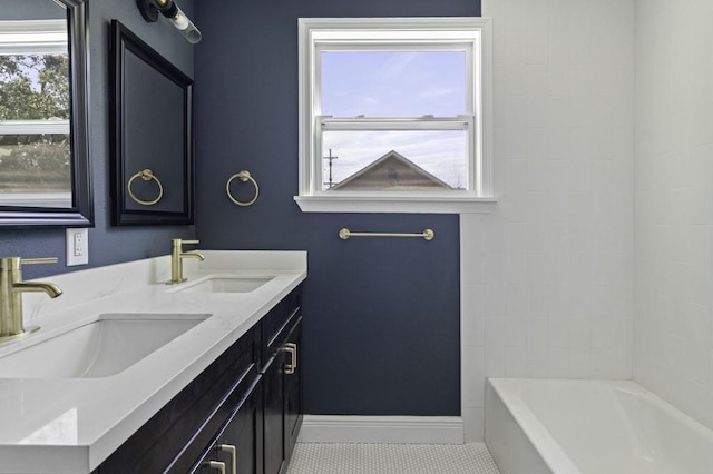 bathroom with tile patterned floors, double vanity, baseboards, and a sink