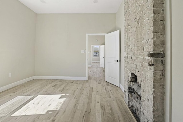 empty room featuring light wood-type flooring and baseboards