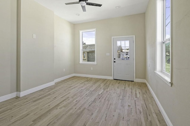 foyer entrance featuring a ceiling fan, baseboards, and light wood finished floors