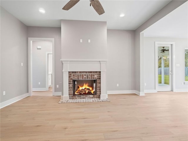 72694 Robindale Dr, Covington, LA 70435 - unfurnished living room featuring light wood-type flooring, baseboards, a ceiling fan, and a brick fireplace