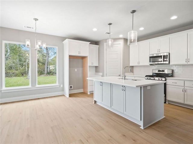 72694 Robindale Dr, Covington, LA 70435 - kitchen featuring light countertops, visible vents, decorative backsplash, stainless steel appliances, and a sink