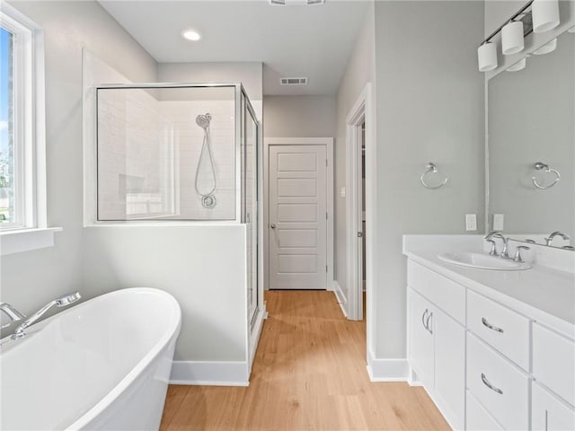 72694 Robindale Dr, Covington, LA 70435 - bathroom with a shower stall, wood finished floors, vanity, and visible vents