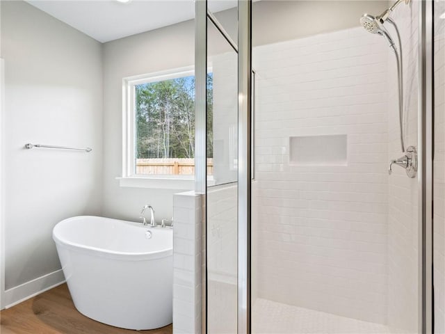 72694 Robindale Dr, Covington, LA 70435 - full bathroom with baseboards, a shower stall, a freestanding tub, and wood finished floors