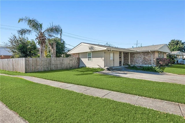 ranch-style home with a front lawn, fence, and driveway