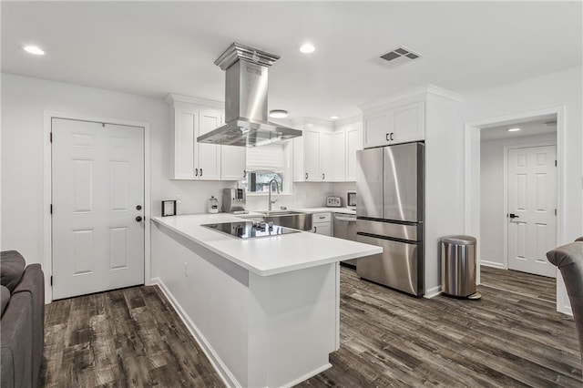 kitchen featuring visible vents, stainless steel appliances, a peninsula, white cabinets, and island range hood