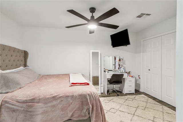 bedroom with a closet, visible vents, ceiling fan, and wood finished floors