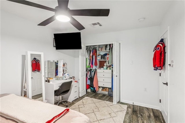 bedroom with visible vents, baseboards, wood finished floors, a closet, and a ceiling fan