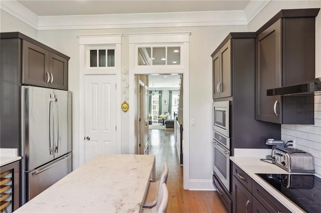 2109 Prytania St, New Orleans, LA 70130 - kitchen featuring stainless steel appliances, wine cooler, light wood finished floors, tasteful backsplash, and crown molding