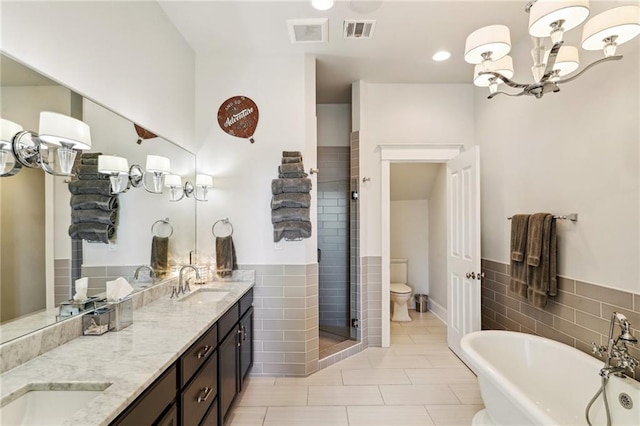 2109 Prytania St, New Orleans, LA 70130 - full bath featuring tile walls, a stall shower, double vanity, a freestanding tub, and toilet