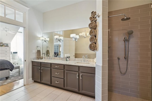 2109 Prytania St, New Orleans, LA 70130 - ensuite bathroom with double vanity, tiled shower, ceiling fan, and healthy amount of natural light