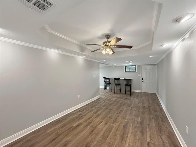 508 Sena Dr, Metairie, LA 70005 - empty room featuring a raised ceiling, a bar, wood finished floors, crown molding, and ceiling fan