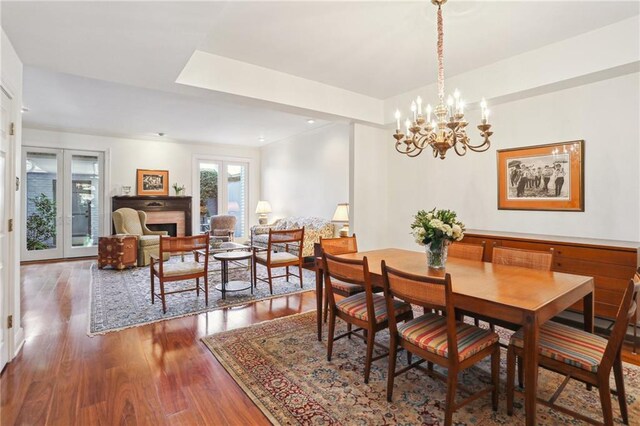 805 Rue Royal St, Metairie, LA 70005 - dining room featuring an inviting chandelier, wood finished floors, and a fireplace