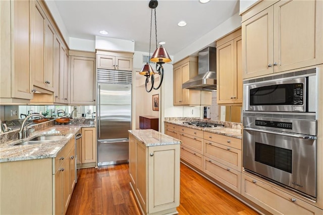 805 Rue Royal St, Metairie, LA 70005 - kitchen featuring wall chimney range hood, light wood-type flooring, built in appliances, and a sink