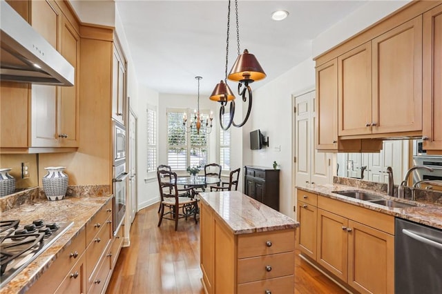 805 Rue Royal St, Metairie, LA 70005 - kitchen with under cabinet range hood, appliances with stainless steel finishes, light wood-style floors, a notable chandelier, and a sink