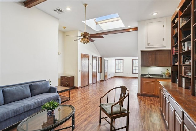 805 Rue Royal St, Metairie, LA 70005 - living room with visible vents, baseboards, lofted ceiling with skylight, wood finished floors, and a ceiling fan
