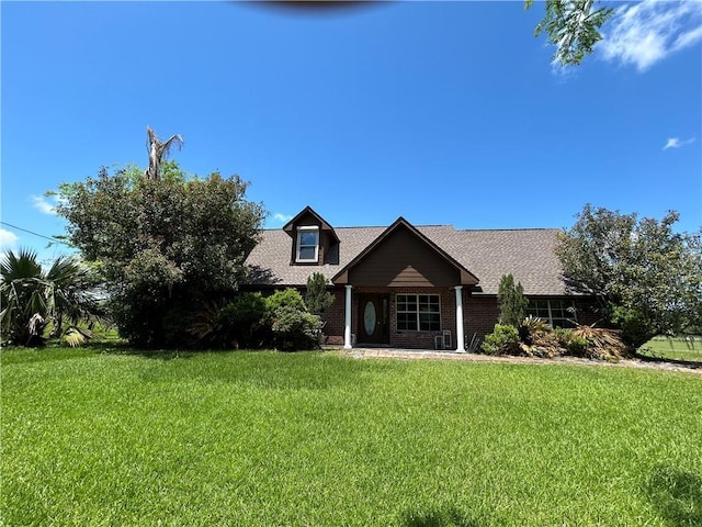 962 Magnolia Ridge Rd, Boutte, LA 70039 - cape cod house with a shingled roof, brick siding, and a front lawn