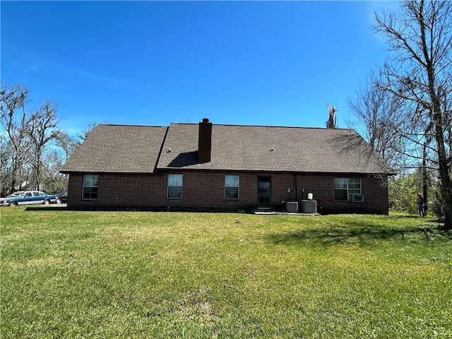 962 Magnolia Ridge Rd, Boutte, LA 70039 - rear view of house featuring a chimney, brick siding, a yard, and cooling unit
