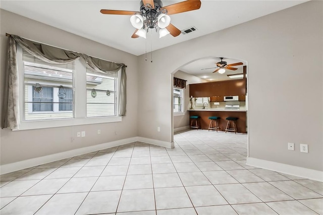 1534 General Collins Ave, New Orleans, LA 70114 - tiled spare room featuring arched walkways, visible vents, baseboards, and ceiling fan