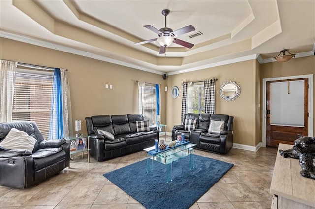 living area featuring baseboards, visible vents, a tray ceiling, light tile patterned flooring, and ceiling fan
