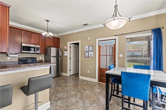 kitchen with decorative light fixtures, ornamental molding, visible vents, and stainless steel appliances