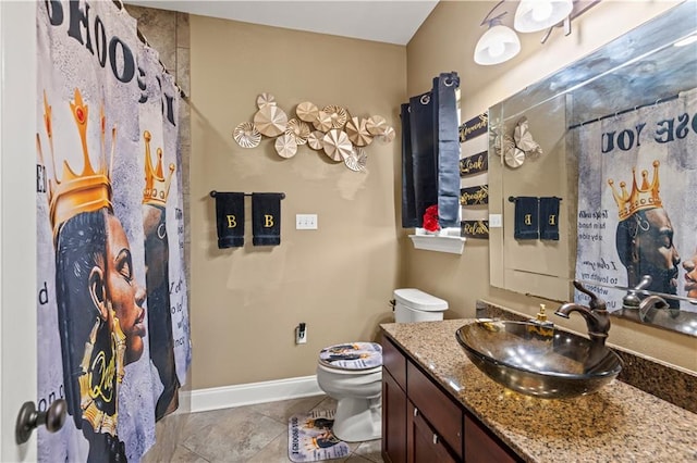 bathroom featuring vanity, toilet, and baseboards