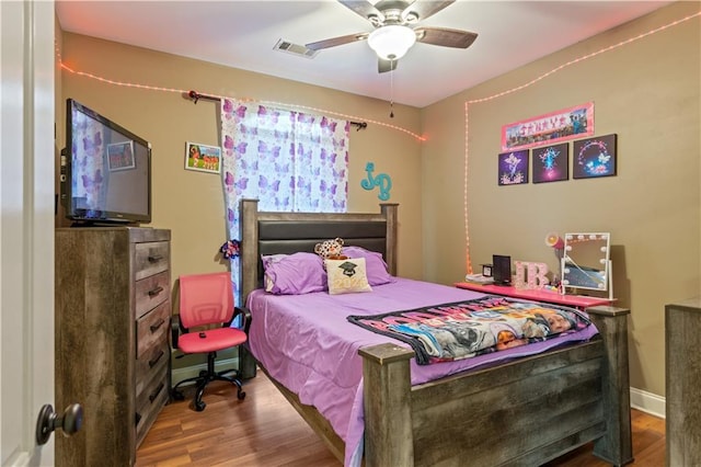 bedroom with visible vents, baseboards, a ceiling fan, and wood finished floors