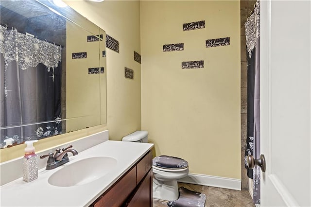 full bath with vanity, toilet, and baseboards