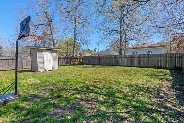 view of yard with an outbuilding, a storage shed, and a fenced backyard