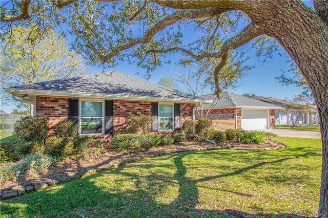 6 Country Club Dr, La Place, LA 70068 - ranch-style home featuring brick siding, a front yard, roof with shingles, a garage, and driveway