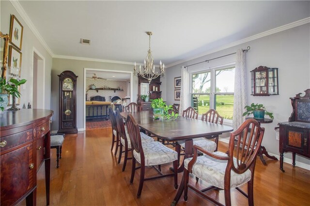 6 Country Club Dr, La Place, LA 70068 - dining space featuring visible vents, crown molding, baseboards, wood finished floors, and a notable chandelier