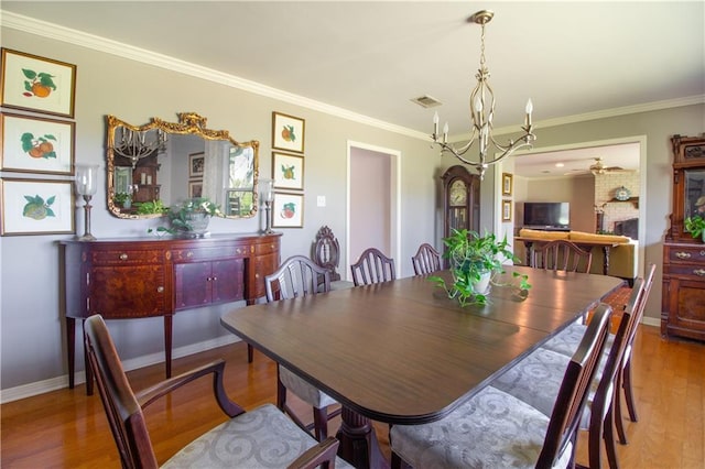 6 Country Club Dr, La Place, LA 70068 - dining room with visible vents, baseboards, ornamental molding, ceiling fan with notable chandelier, and wood finished floors