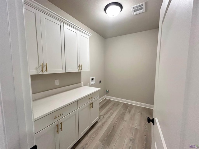 25307 Angele Dr, Ponchatoula, LA 70454 - laundry room featuring electric dryer hookup, cabinet space, light wood-style floors, and hookup for a washing machine